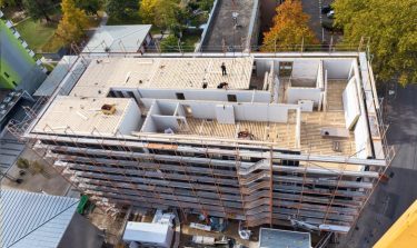 Die Wohnungsdecken wurden mit materialefﬁzienten Brettsperrholz-Rippendecken ausgeführt. Ihre Kammern werden im weiteren Bauablauf für die Verlegung von Leitungen genutzt, anschliessend mit schalldämmendem Kalksplitt verfüllt.