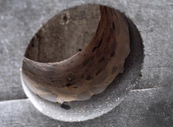 Kernbohrung in einem instand gesetzten Fassadenelement mit Basaltbeweh-rung in einer Mörtelschicht.