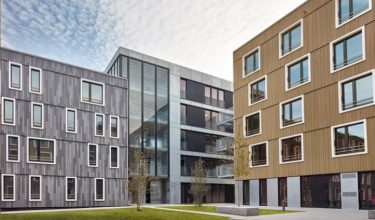 Mit den wirtschaftlichen Spannbeton-Fertigdecken und den verschiedenfarbigen Fassaden aus Holz lassen sich alle bauphysikalischen Anforderungen erfüllen.