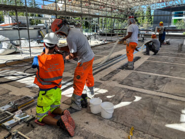 Reinigung und Positionierung der dritten vorgespannten Lamelle auf der Oberseite des zentralen Hauptunterzugs.