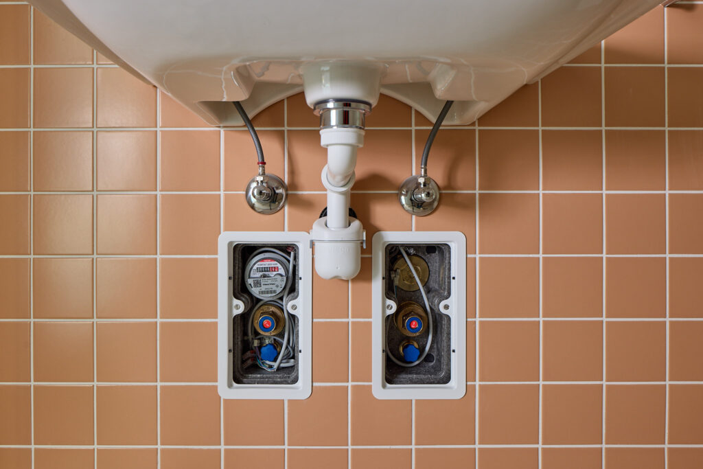 Die zwei Nussbaum UP-Boxen mit gedämmter Optiflex-Verteiler-Box, hier mit geöffneten Abdeckplatten, enthalten unter anderem die Wasseruhr, je eine Druckreduzierpatrone sowie die Abstellarmatur. (Foto: pd)